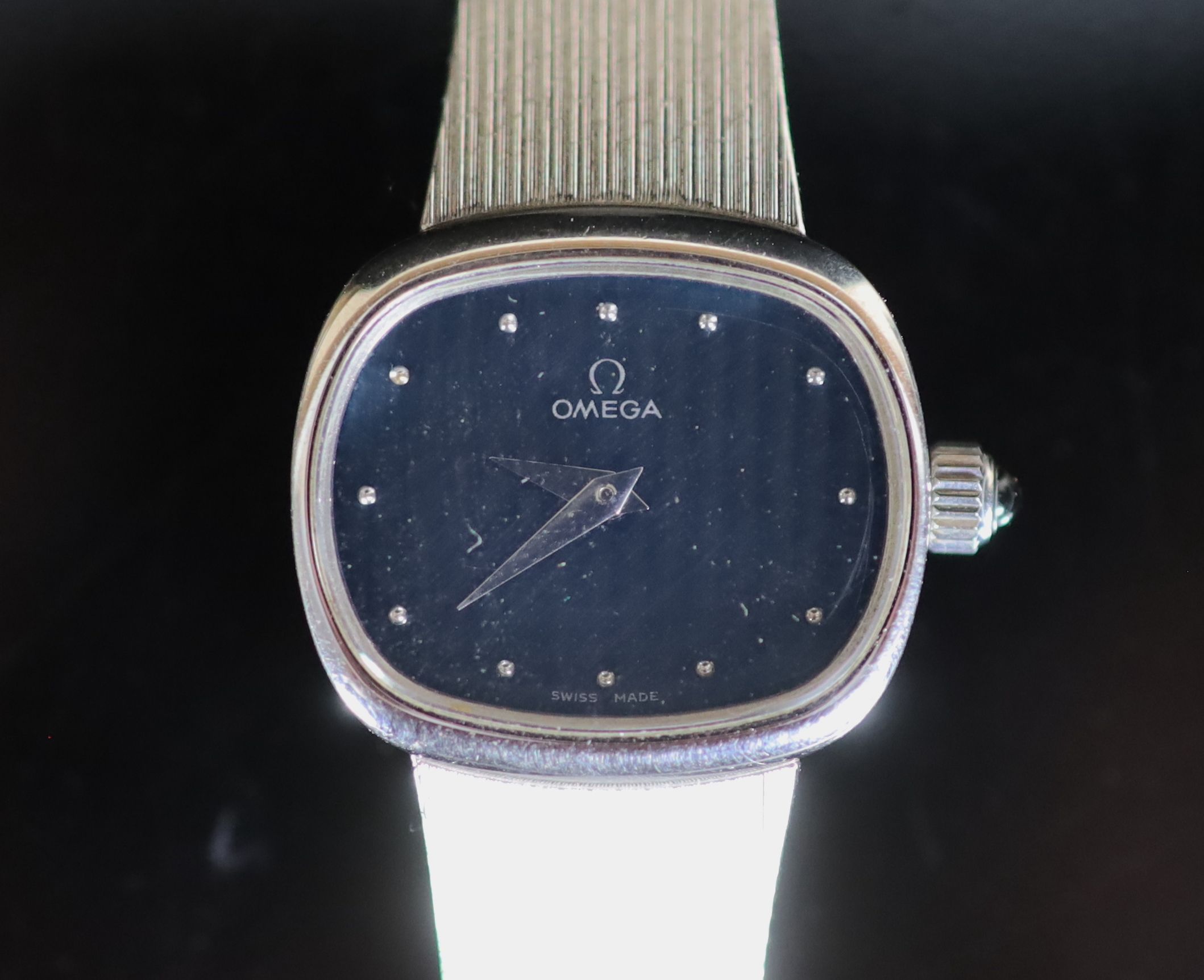 A lady's modern 9ct white gold Omega manual wind wrist watch, on an integral Omega 9ct white gold bracelet